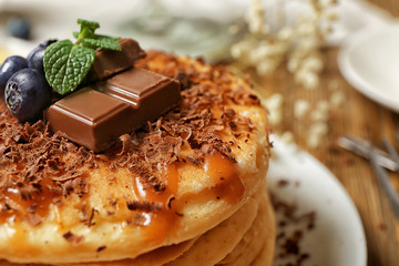 Stack of fresh pancakes with chocolate on plate