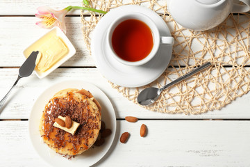 Stack of fresh pancakes with nuts on wooden table
