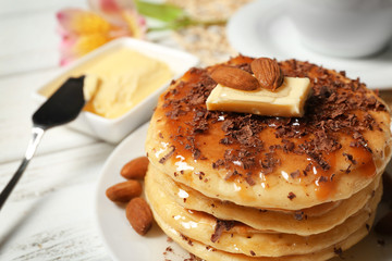 Stack of fresh pancakes with nuts on plate