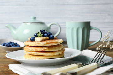 Stack of fresh pancakes with fruits on plate