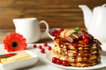 Stack of fresh pancakes with chocolate sauce on plate