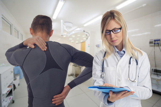 Man patient suffering from back pain during medical exam by doctor rheumatologist. Sports exercising injury.