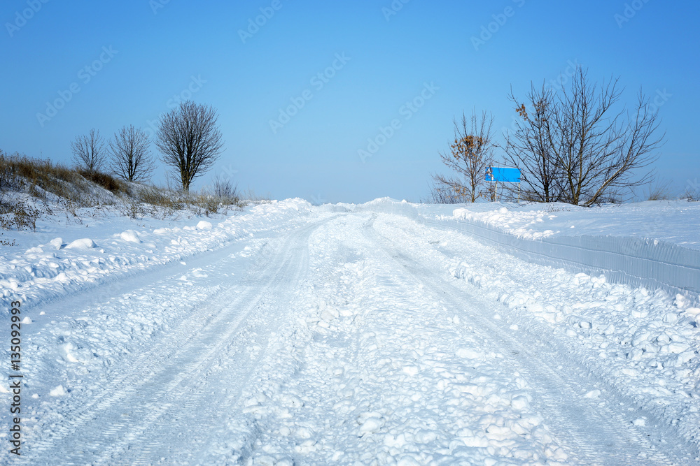 Sticker country side empty road covered with snow on sunny day