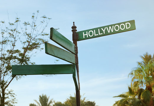 Street sign with word HOLLYWOOD on sky background