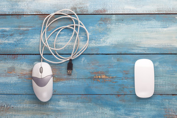 Wired and wireless mouse on a blue wooden board
