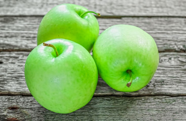 Ripe green apples on wooden background
