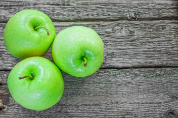 Ripe green apples on wooden background