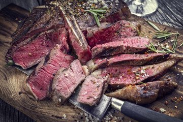 Barbecue aged Wagyu T-Bone Steak sliced on a Cutting Board
