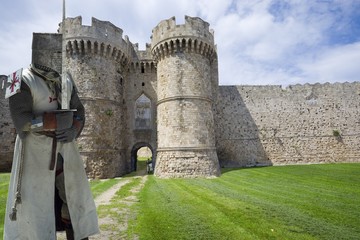 Fototapeta na wymiar Medieval knight with fortifications of the Old Town of Rhodes - Marine Gate (Sea Gate), Greece