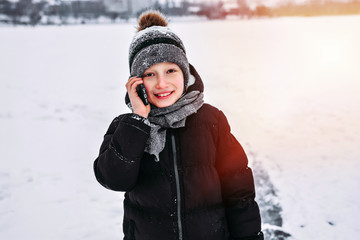 Fototapeta na wymiar boy talking on the phone outdoors in winter