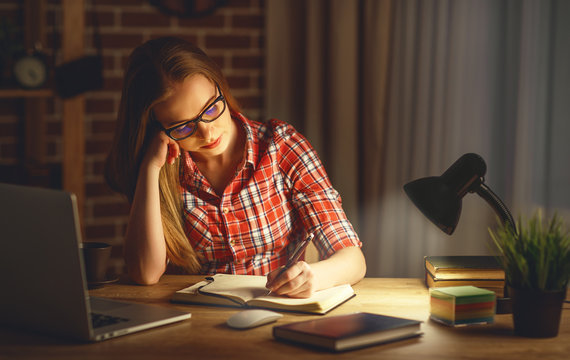 Young Woman Student Working On The Computer At Night