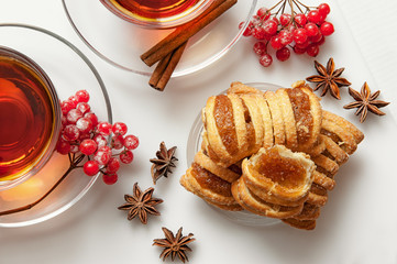 a pie with a filling of marmalade on a plate decorated with the snowball, anise, cinnamon tea into transparent glass cups
