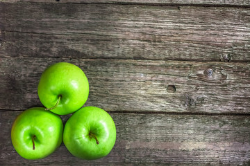 Ripe green apples on wooden background