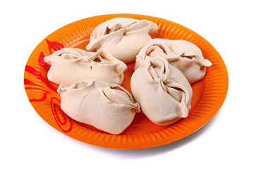 Frozen manti laying on the orange plate