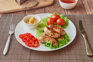 Grilled sausages with beer on a wooden background.