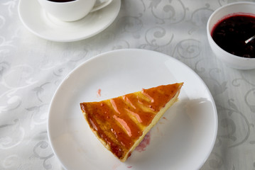 Slice of the New York cheesecake on a white plate on a wooden background 