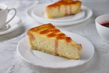 Slice of the New York cheesecake on a white plate on a wooden background 