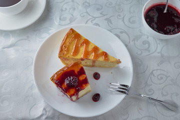 Slice of the New York cheesecake on a white plate on a wooden background 