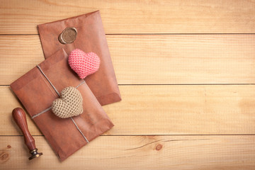 Retro style envelopes and crochet hearts on wooden background