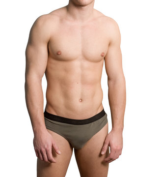 Torso of a young hairless man wearing briefs over white background