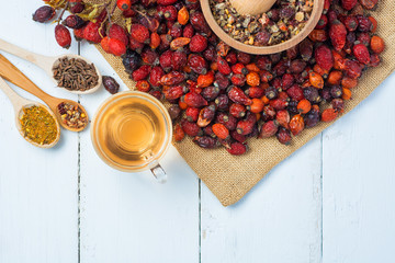 Medicinal plants and herbs composition Pile of dried rose hips and Dog rose, bunch branch Rosehips, types Rosa canina. Herbal tea on white