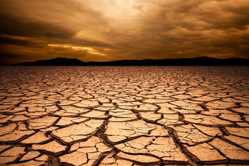 dramatic sunset over cracked earth. Desert landscape background. - obrazy, fototapety, plakaty