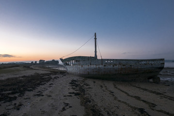 Fototapeta na wymiar Sunset and old shipwreck in Arz Island in Brittany (Morbihan), F