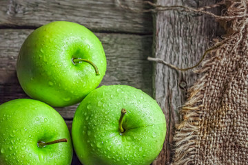 Ripe green apples on wooden background