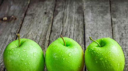 Ripe green apples on wooden background