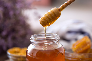 dripping sweet fresh honey from wooden dipper.