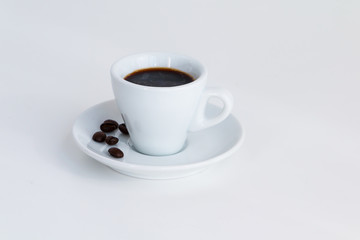 Cup of espresso coffee and coffee beans on white desk