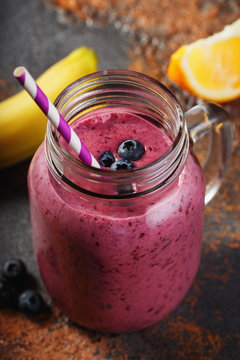 Smoothies of blueberry, banana and orange in a glass jar