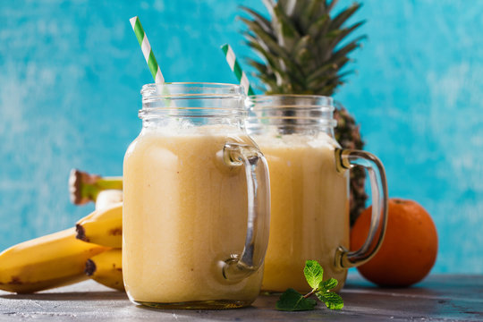 Smoothies of pineapple, banana and orange in a glass jar