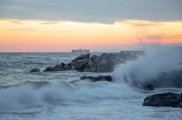 Wave in rough sea at sunset, long exposure