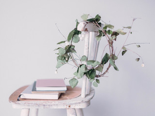 selbstgemachter kranz hängt an lehne eines vintage stuhls