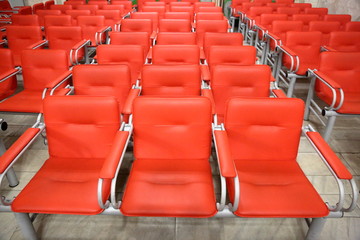 Fototapeta premium Armchairs with metal frame and red leather upholstery in a row