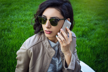 young woman in sunglasses talking phone