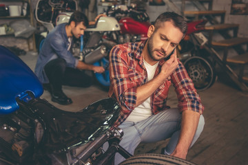 Fototapeta na wymiar Guys at the motorbike repair shop