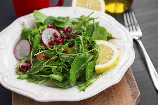 Healthy salad with baby spinach, pomegranate and rucola seasoned