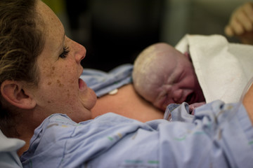Obraz na płótnie Canvas Freshly born baby skin to skin on mothers chest caucasian female
