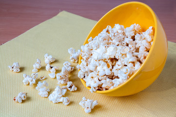 Inverted cup with yellow popcorn on the table