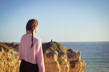 Woman on the ocean sunny blue sky background. Back side view. , adventure, nostalgic experience, holiday