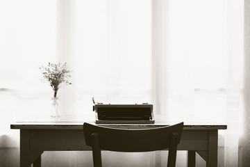 Vintage typewriter and dry flowers front a window 
