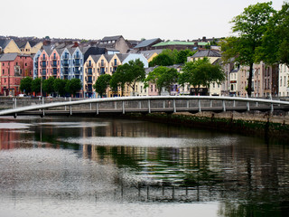 A row of colorful buildings near a bridge over the quay in Cork Ireland.