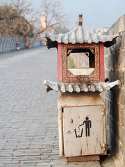 A trash can on the street of the old city of Dali China has been shaped to look like a traditional oriental building.