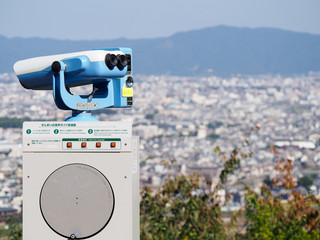 Coin operated binoculars at an overlook in Kyoto Japan on a bright sunny day.