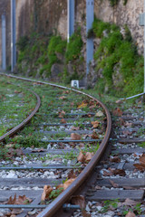 old rails for train a near of stone wall