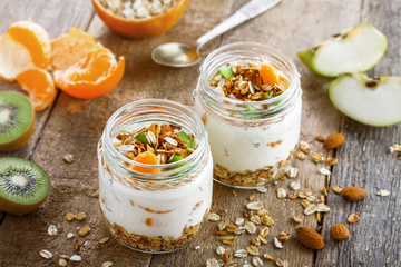 Granola with yogurt and fruits in a rustic jar. Delicious healthy American food for breakfast. Traditional US snack.