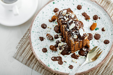 Tasty piece of chocolate Spartak cake on a rustic plate. Traditional delicious dessert on a table. Top view shot.