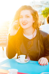 Woman sitting in restaurant cafe table on sunny background outdoors